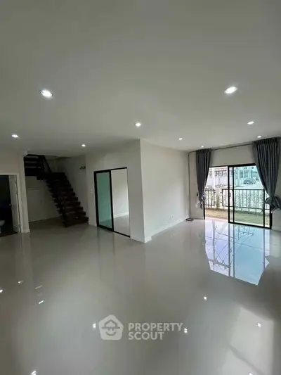 Spacious modern living room with glossy floors and balcony view