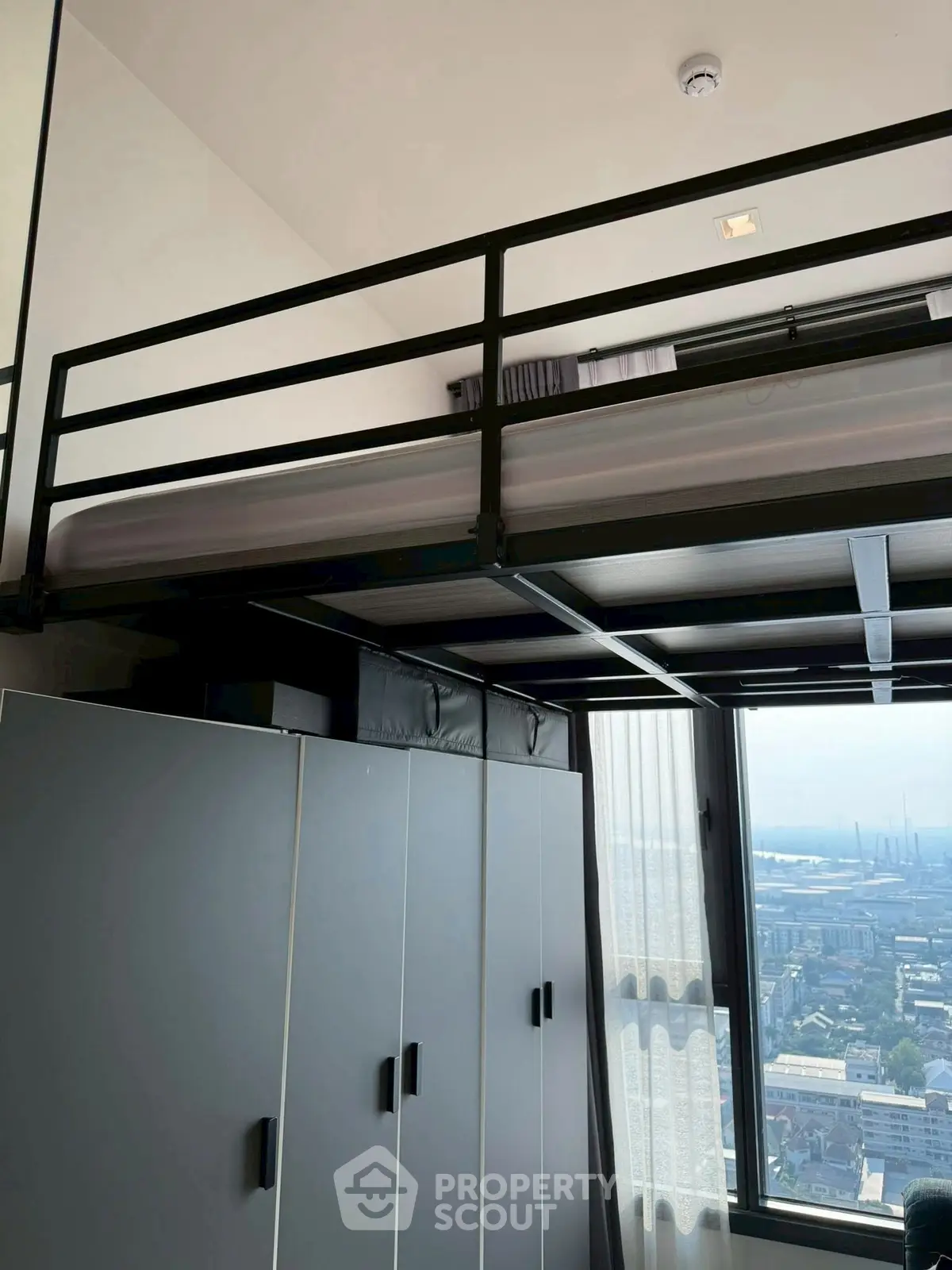 Modern loft bedroom with city view and sleek storage cabinets