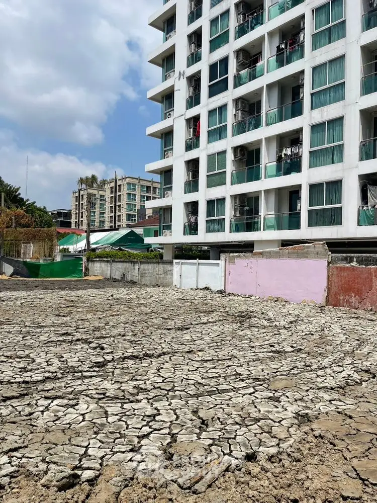 Urban apartment building with adjacent dry land, potential development site.