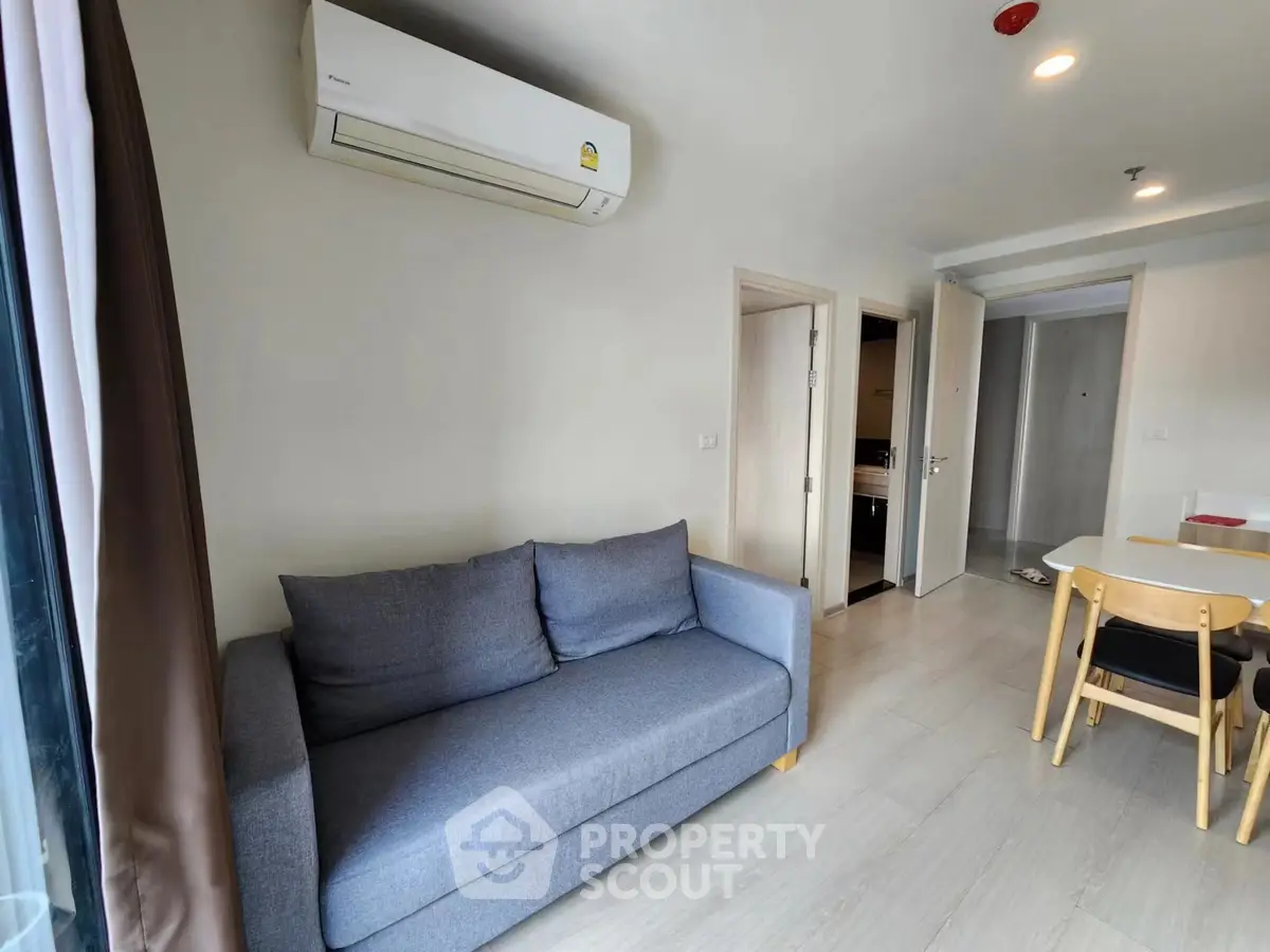 Modern living room with sleek sofa and dining area in open layout apartment