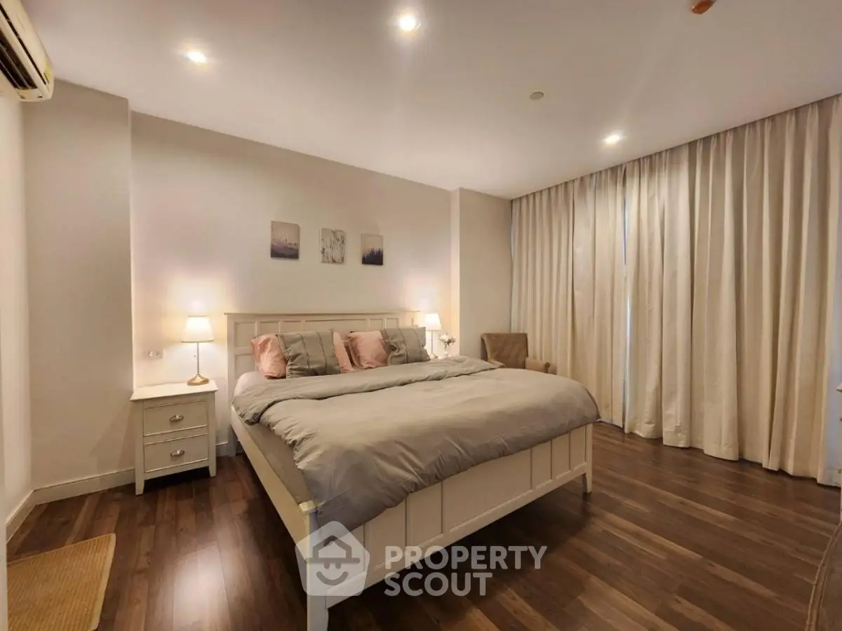 Spacious bedroom with elegant decor and cozy lighting in modern apartment.
