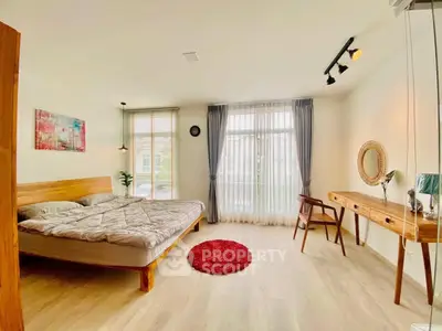 Spacious bedroom with modern decor and natural light in a stylish apartment.