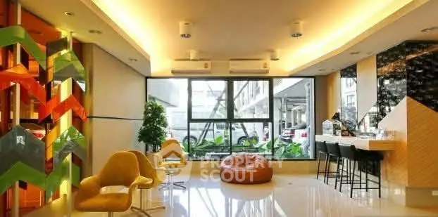 Modern living room with vibrant decor and large windows in a stylish apartment.