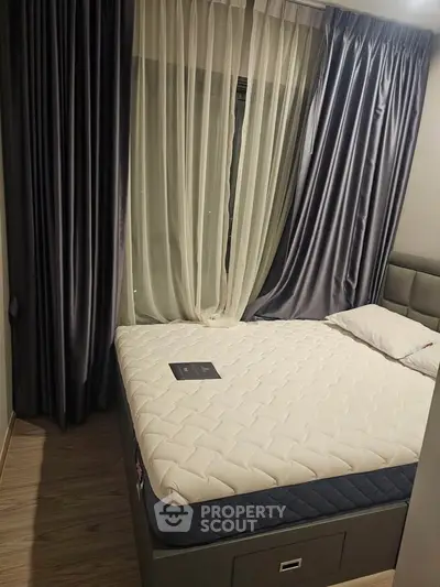 Cozy bedroom with elegant curtains and a comfortable bed, perfect for restful nights.