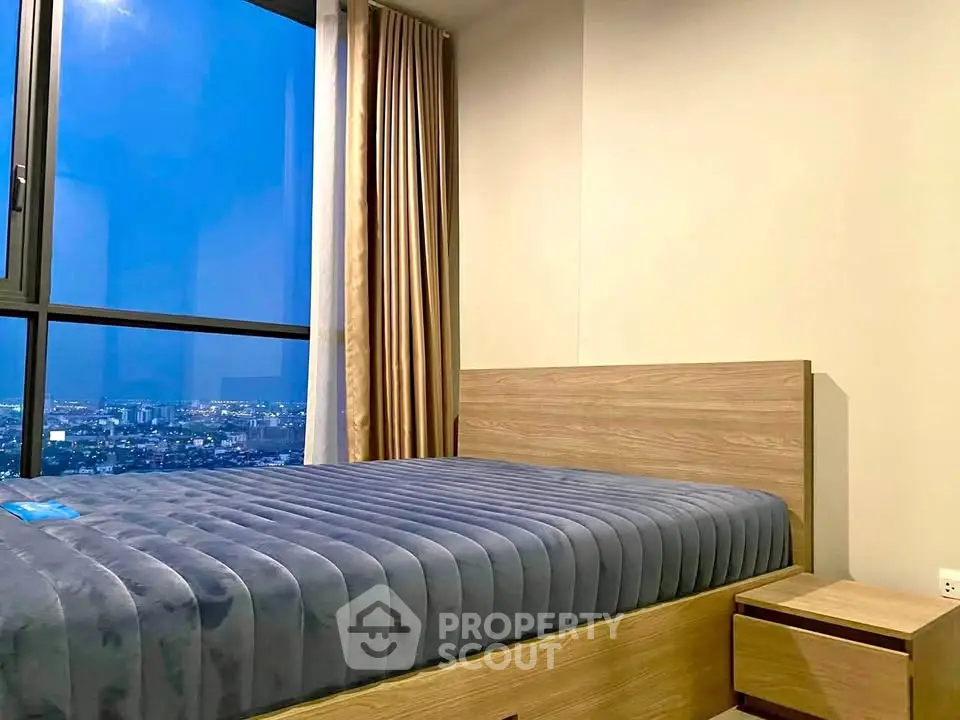 Modern bedroom with large window offering stunning city view
