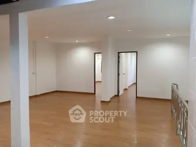 Spacious open-plan interior with wooden flooring and bright lighting, ideal for versatile living arrangements.
