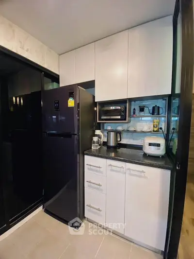 Modern kitchen with sleek appliances and ample storage in a stylish apartment.