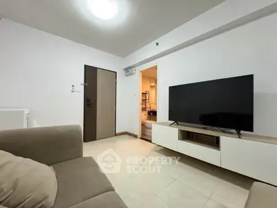Modern living room with sleek TV setup and cozy sofa in a contemporary apartment.