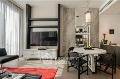 Modern living room with stylish furniture and elegant decor, featuring a TV unit and dining area.