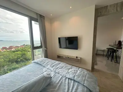 Modern bedroom with stunning ocean view and wall-mounted TV