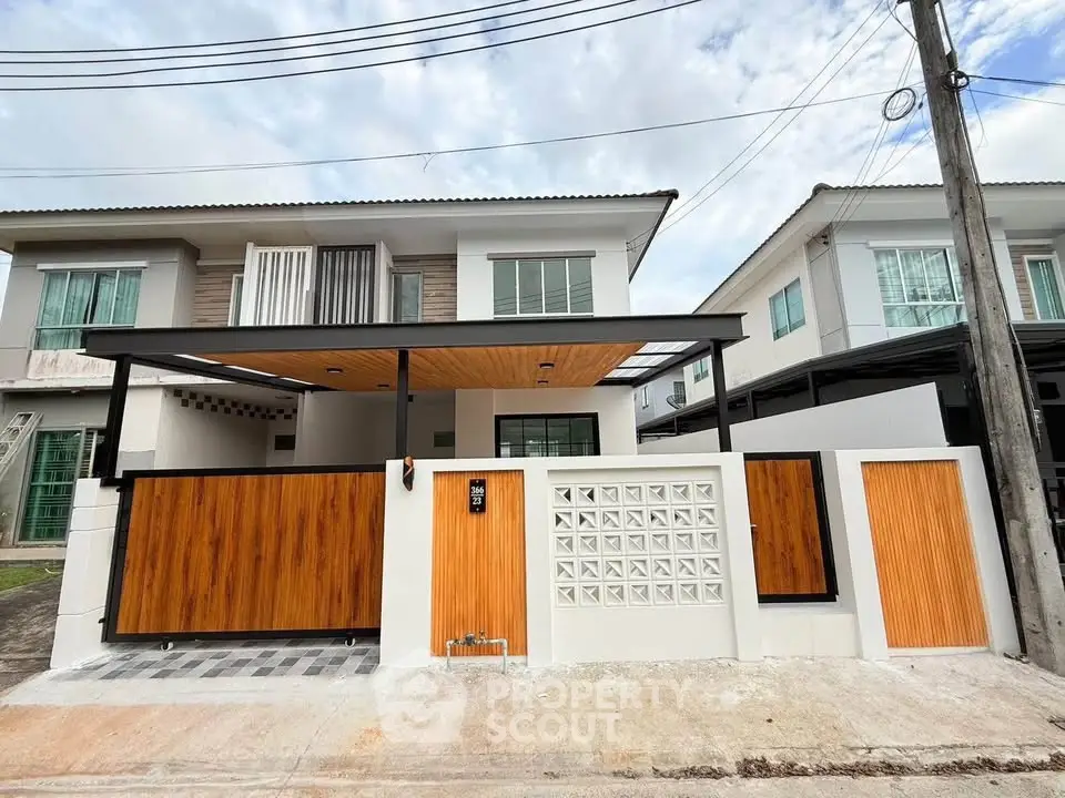 Modern two-story house with stylish wooden gate and contemporary design.
