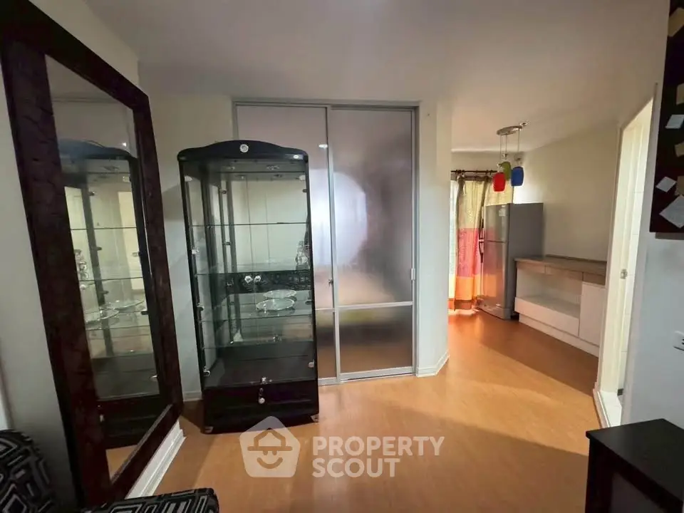 Spacious living area with modern glass cabinet and sliding doors