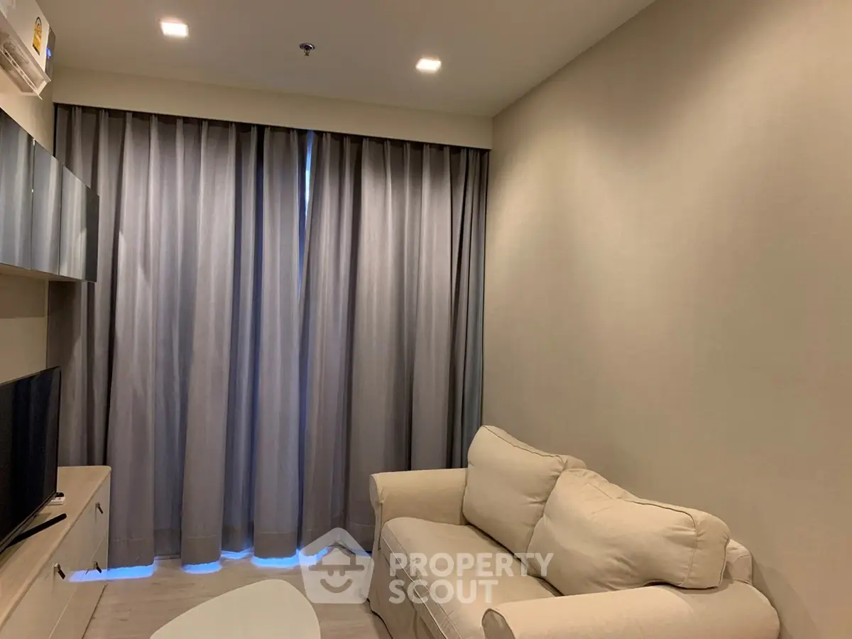 Cozy living room with modern sofa and entertainment unit, perfect for relaxation.
