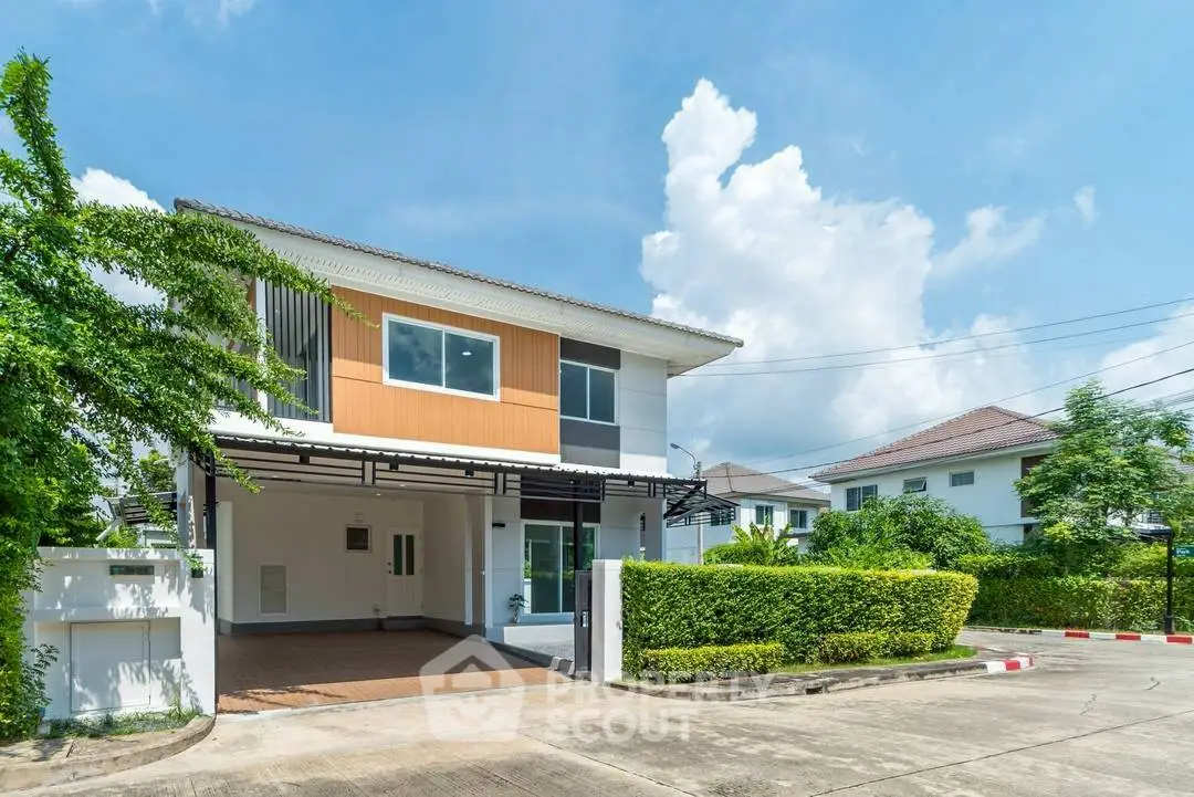 Modern two-story house with lush greenery and spacious driveway in a serene neighborhood.