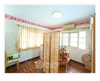 Charming bedroom with wooden flooring and ample natural light