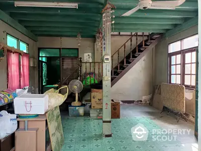 Spacious living area with vintage decor and wooden staircase in a classic home