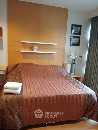 Cozy bedroom with modern decor and warm lighting, featuring a comfortable bed and elegant wall art.