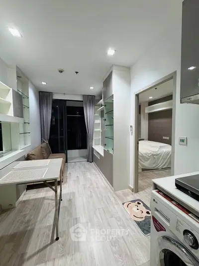 Modern apartment interior with open layout, featuring a cozy living area and visible bedroom.