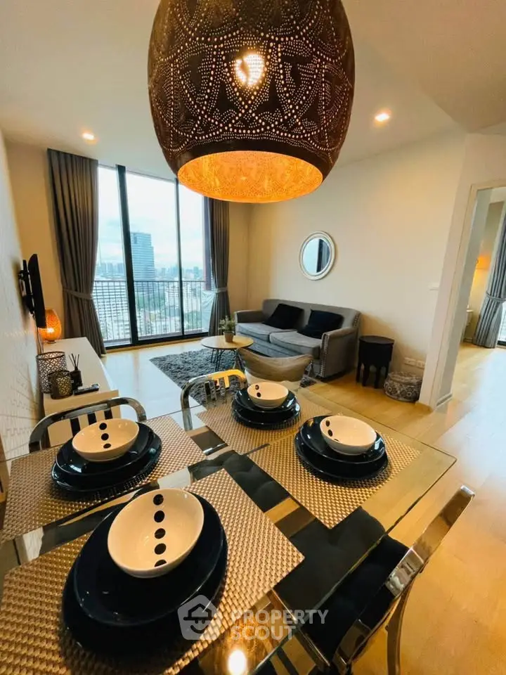 Modern living room with dining area and city view, featuring elegant decor and stylish lighting.