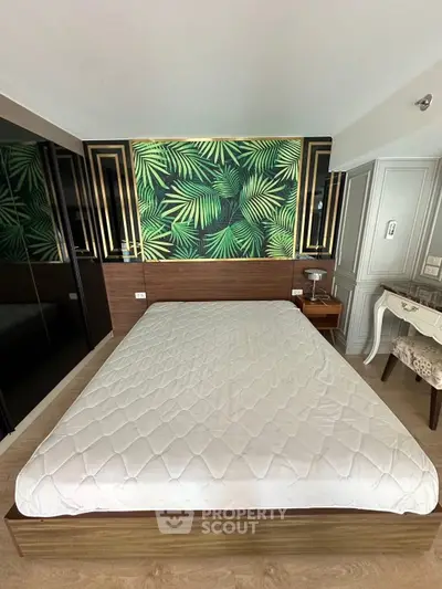 Stylish bedroom with modern decor and vibrant leaf-patterned accent wall