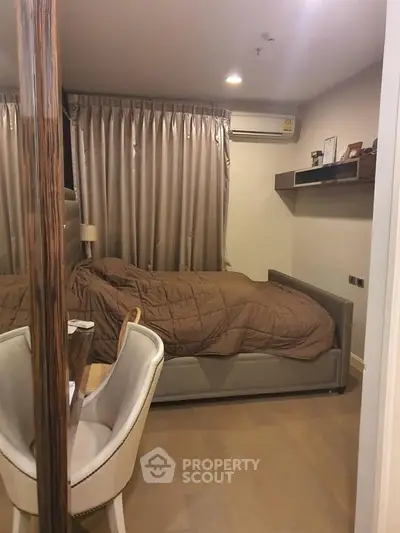 Cozy bedroom with modern decor and air conditioning, featuring a comfortable bed and elegant curtains.