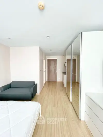 Spacious and modern studio apartment with sleek furniture, ample natural light, and a versatile open floor plan perfect for urban living.