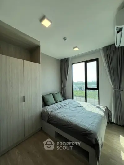 Modern bedroom with large window and stylish decor, offering a serene and cozy atmosphere.