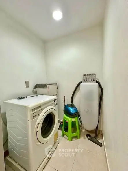 Compact laundry room with washing machine and ironing board, ideal for efficient home organization.
