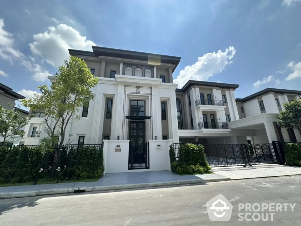 Luxurious modern villa with elegant facade and lush greenery under a clear blue sky.