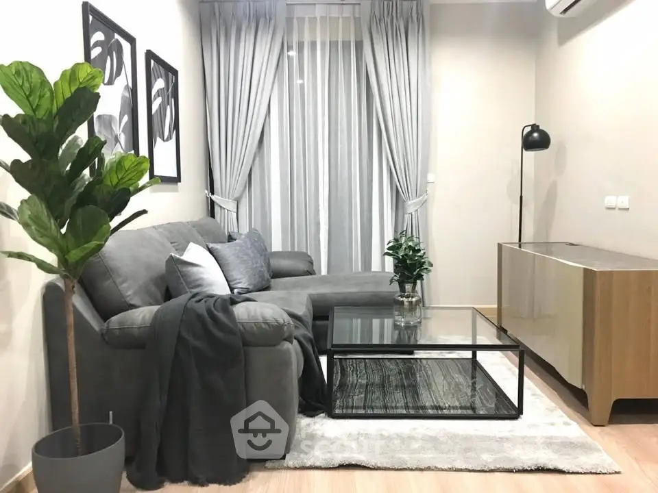 Modern living room with stylish gray sofa, glass coffee table, and elegant decor.