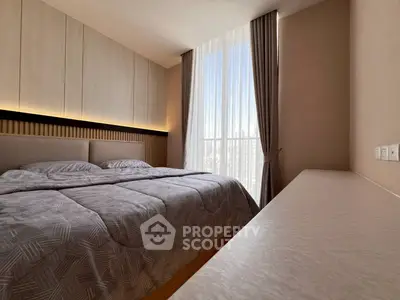 Modern bedroom with large window and stylish decor in a high-rise apartment.