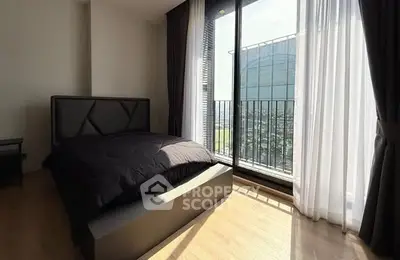 Modern bedroom with large windows and balcony offering stunning city views.