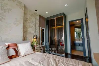 Elegant bedroom with modern decor and ensuite bathroom, featuring stylish lighting and a cozy atmosphere.