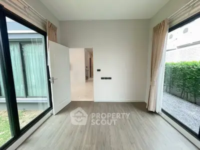 Bright and airy room with large windows and modern flooring, perfect for a cozy living space.