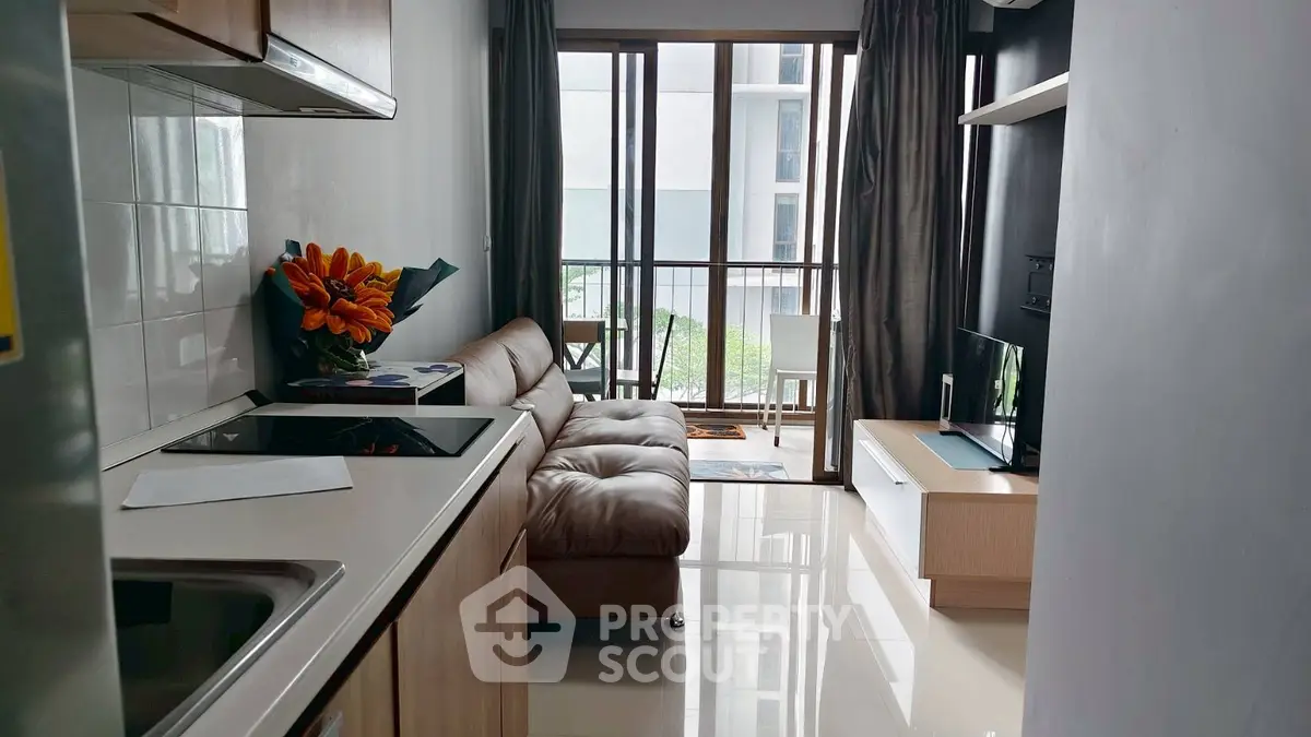 Modern compact living room with sleek kitchen and balcony view