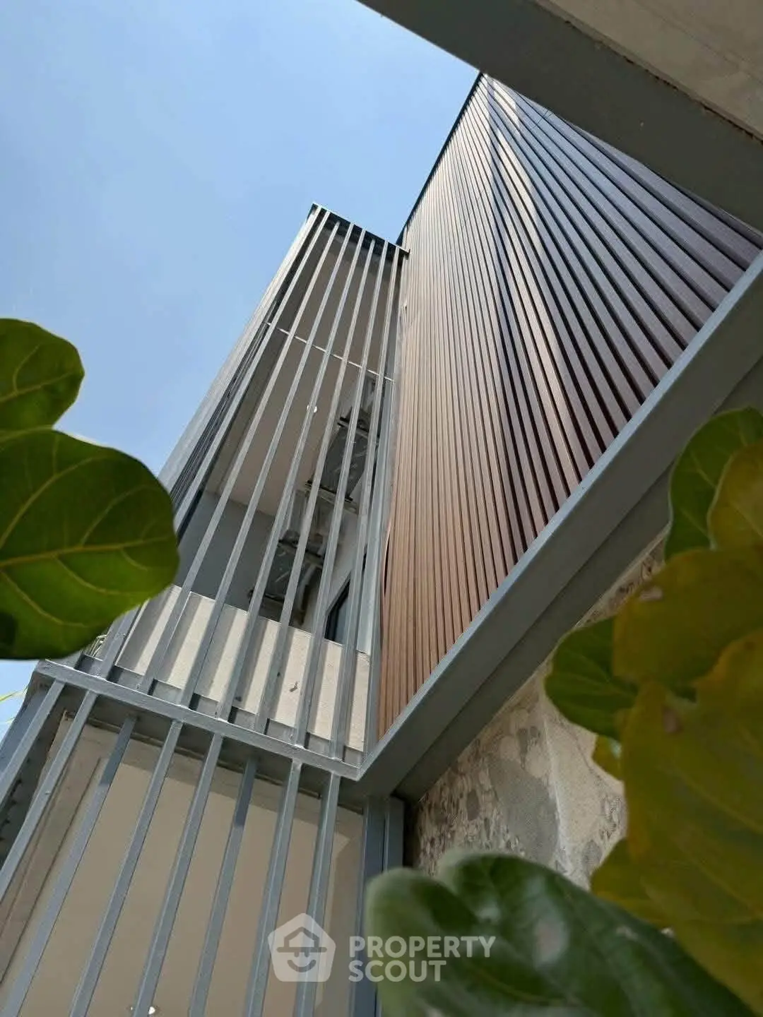 Modern architectural exterior with sleek vertical slats and lush greenery.