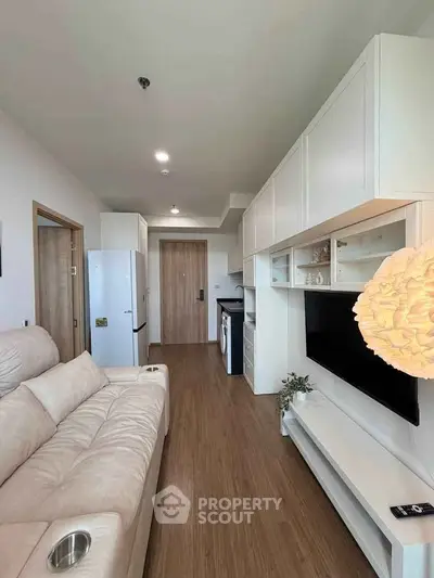 Modern living room with sleek furniture and built-in storage in a cozy apartment.