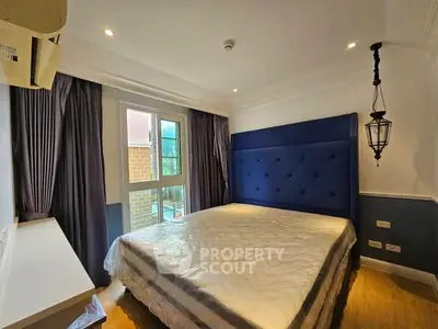 Cozy bedroom with elegant blue headboard and ample natural light