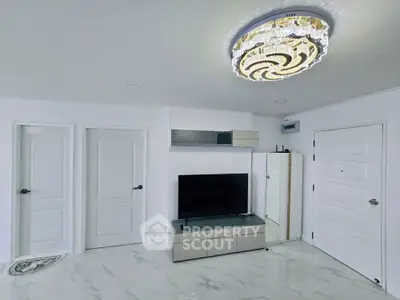 Modern living room with elegant chandelier and sleek TV setup