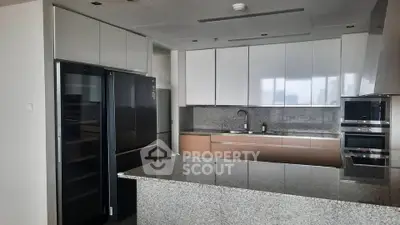 Modern kitchen with sleek cabinetry and granite countertops in luxury apartment