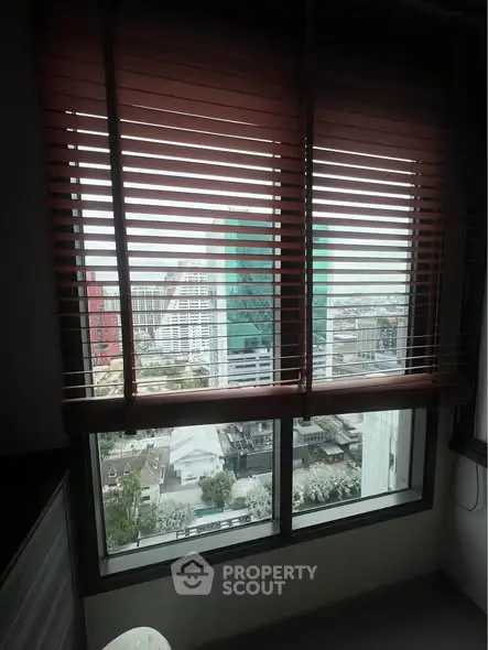Stunning city view through modern window blinds in high-rise apartment