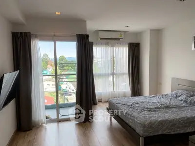 Spacious bedroom with large windows and balcony offering scenic views