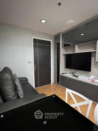 Modern living room with sleek furniture and wall-mounted TV in a stylish apartment.