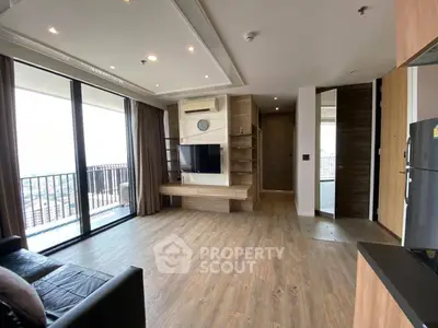 Spacious modern living room with balcony and wooden flooring in high-rise apartment.