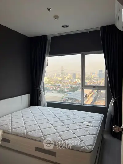 Modern bedroom with large window offering stunning city view, featuring a comfortable mattress and sleek design.