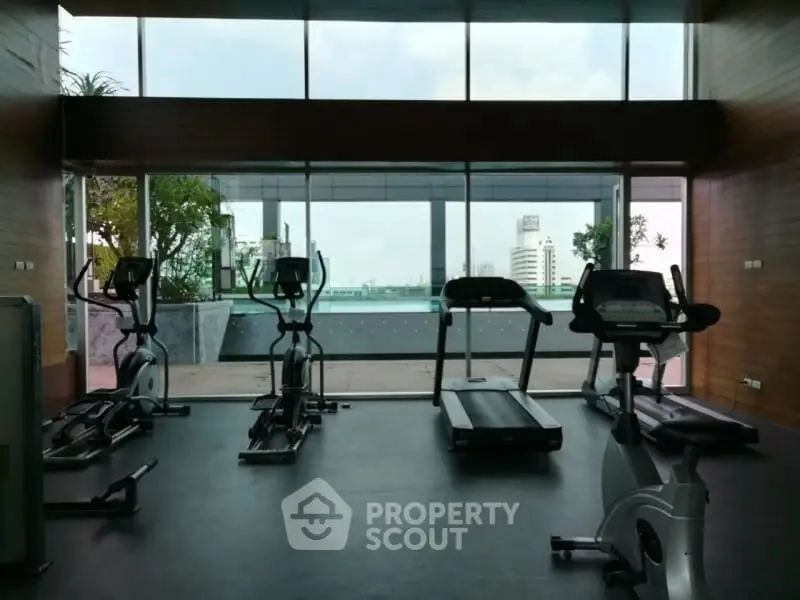 Modern gym with city view and exercise equipment in luxury building