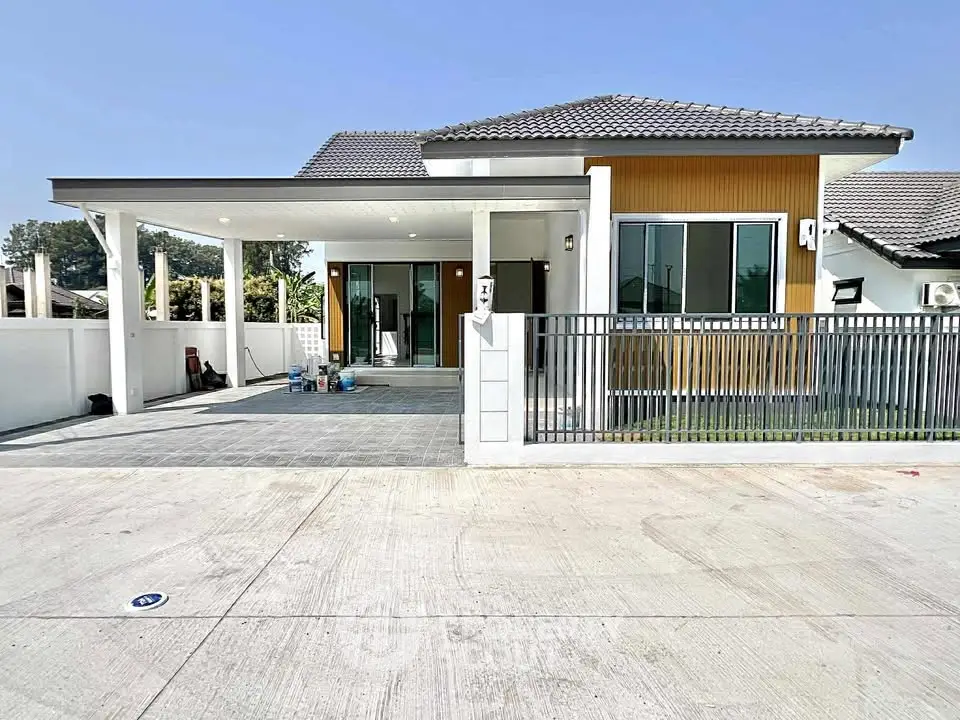 Modern single-story house with spacious driveway and stylish facade.