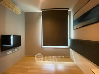 Modern minimalist room with wooden flooring and wall-mounted TV, ideal for cozy living.