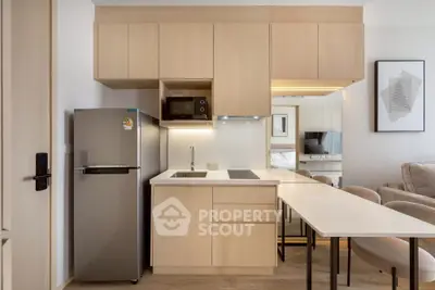 Modern compact kitchen with sleek cabinetry and integrated appliances in a stylish apartment.