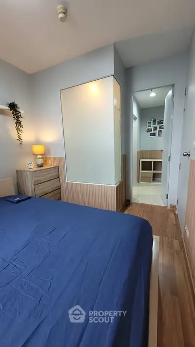 Cozy bedroom with modern decor and wooden flooring, featuring a comfortable bed and stylish furniture.